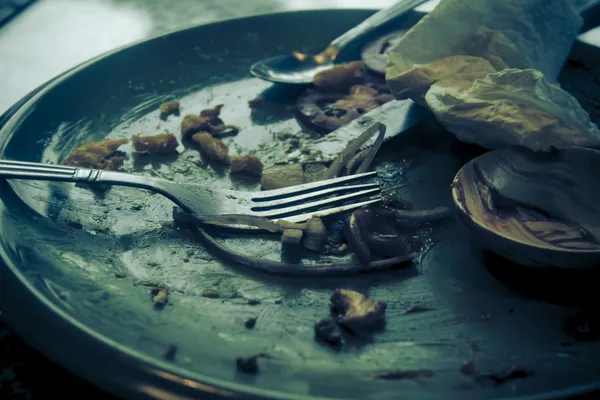 Kirli tabaklar çatal ve bıçak bitmiş bir yemekten sonra yeşil bir plaka üzerinde