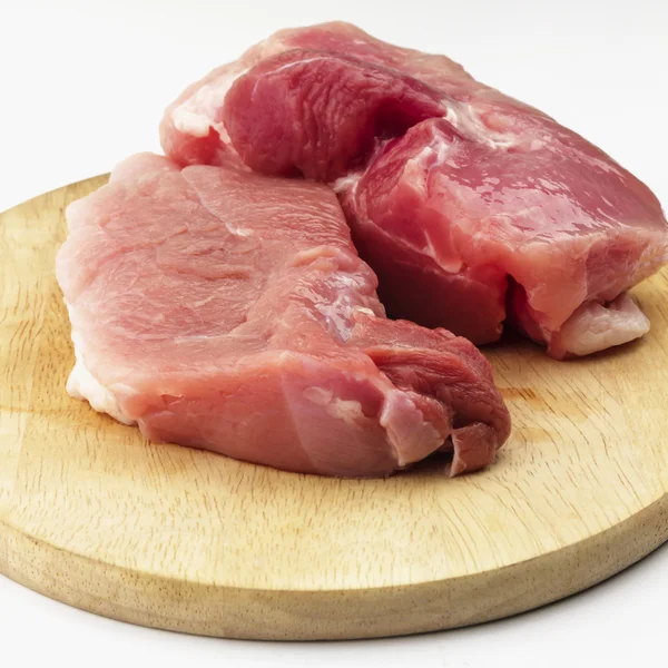 Presunto de porco cru na placa de corte de madeira no fundo branco — Fotografia de Stock