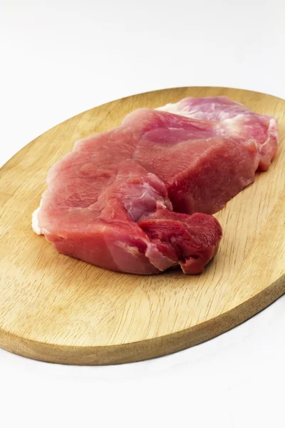 Jamón de cerdo crudo sobre tabla de cortar de madera sobre fondo blanco Fotos De Stock Sin Royalties Gratis