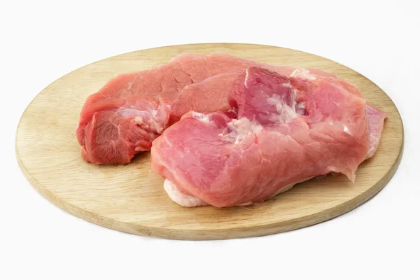 Presunto de porco cru na placa de corte de madeira no fundo branco Fotografia De Stock