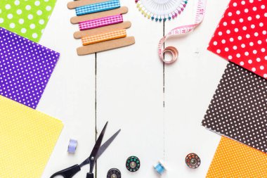 Hafif ahşap arka plan dikmek için çeşitli kumaş, alet ve aksesuarlarla yapılmış. Üst görünüm, alanı kopyala.