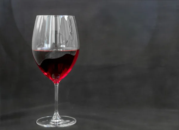 Wijnglas met rode wijn, grijze achtergrond — Stockfoto