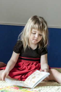 Küçük kız kitap okuyor.