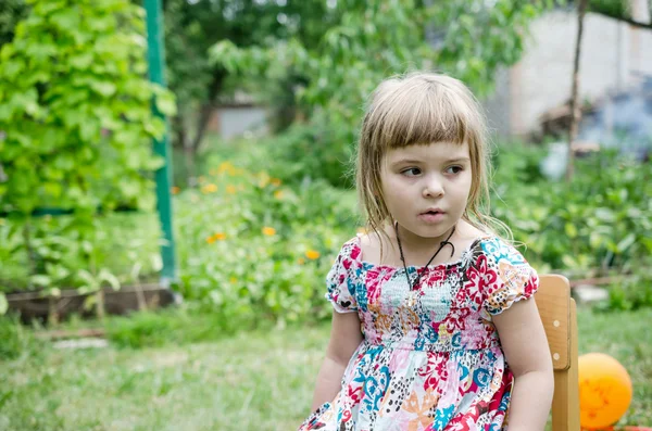 Little girl sitting on the chair outdoor — Stock Photo, Image