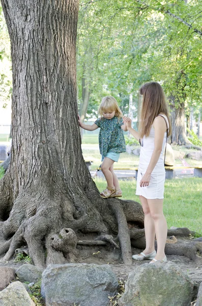 Flicka som leker med mamma i parken — Stockfoto