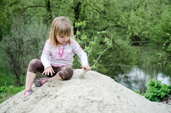 Girl plays in sandbox — Stock Photo, Image