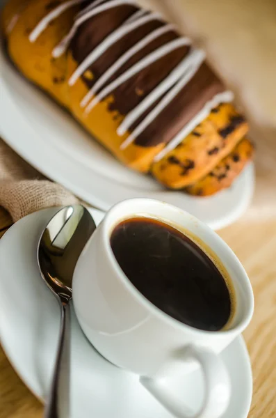 Chocolate bun with cup of coffee — Stock Photo, Image