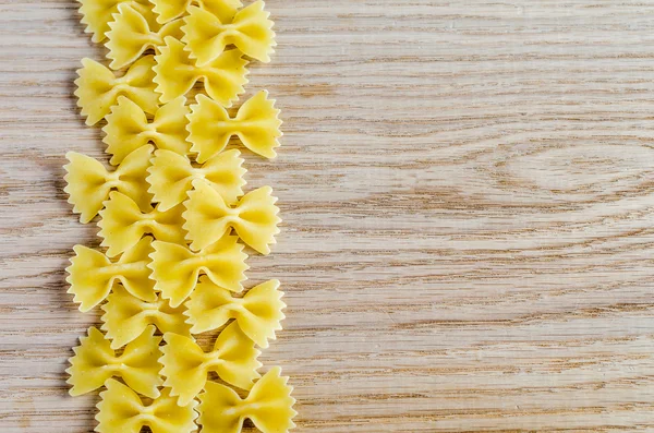 Farfalle ongekookt pasta achtergrond — Stockfoto