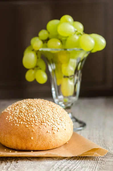 Sesame bun and bunch of grapes — Stock Photo, Image