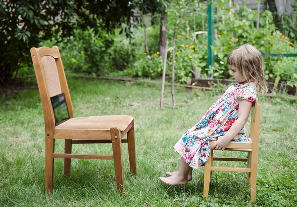 Flickan tittar på film i trädgården — Stockfoto
