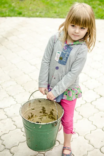 Lilla flickan bär stora hinken — Stockfoto