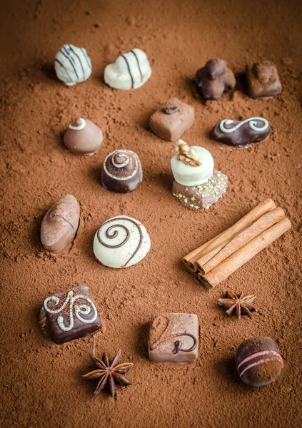 Роскошные шоколадные конфеты на фоне какао — стоковое фото