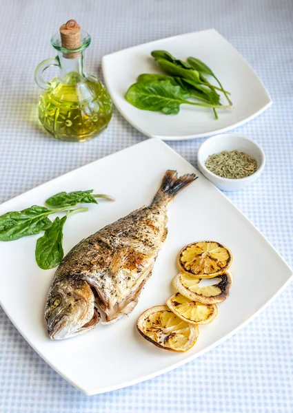 Gegrilde dorada vis met citroen en spinazie — Stockfoto