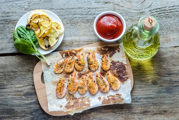 Camarones con limón y salsa picante en el fondo de madera —  Fotos de Stock