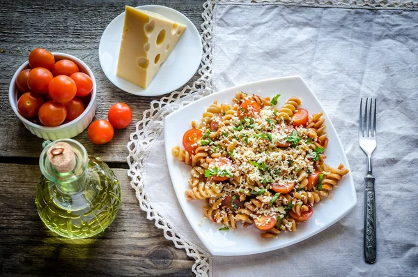 Makaron fusilli pełnoziarniste z serem i pomidorami koktajlowymi — Zdjęcie stockowe