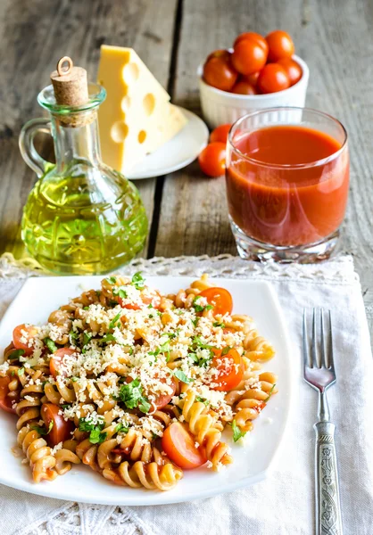 Whole wheat fusilli pasta with cheese and cherry tomatoes — Stock Photo, Image