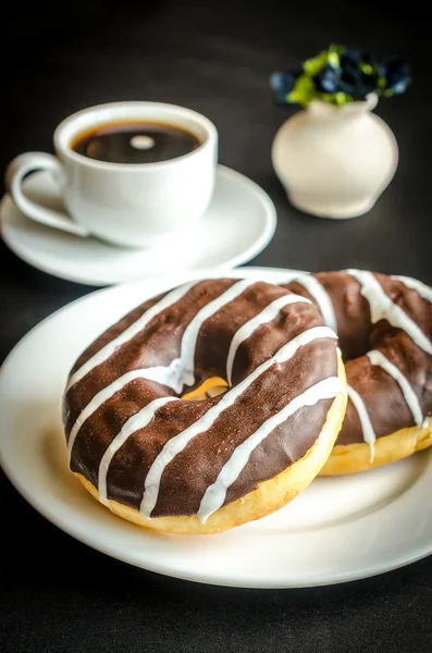 Donuts de chocolate con una taza de café — Foto de Stock
