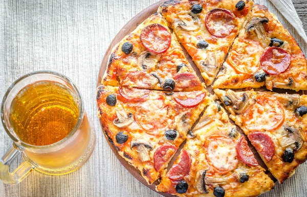 Homemade pizza with a glass of beer — Stock Photo, Image