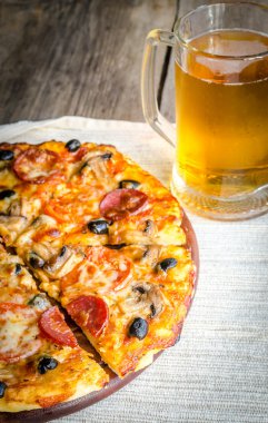 Homemade pizza with a glass of beer clipart