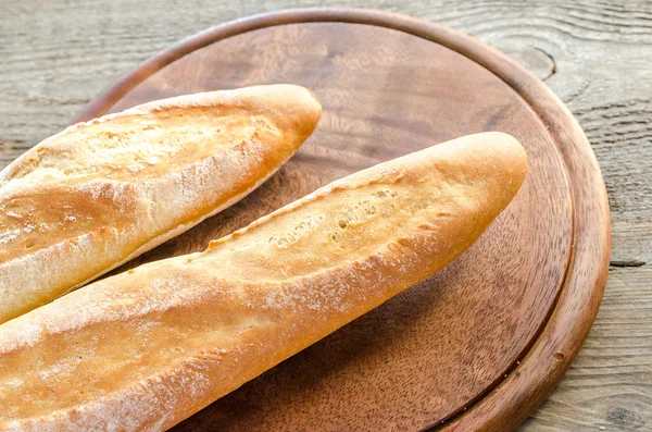 Two baguettes on the wooden board — Stock Photo, Image