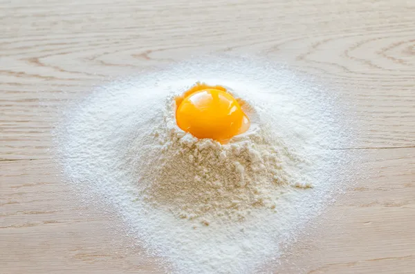 Broken egg in flour — Stock Photo, Image