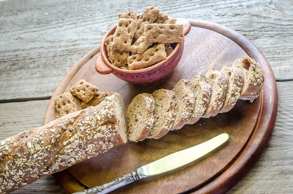 Baguette with crisps on the wooden tray — Stock Photo, Image