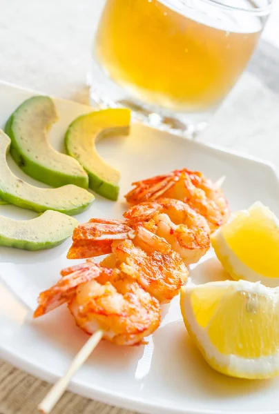 Shrimps skewers with avocado and lemon slices — Stock Photo, Image