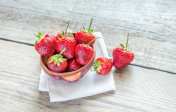 Fragole fresche nella ciotola sul tavolo di legno — Foto Stock