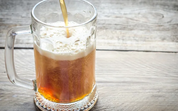 Beer pouring into mug — Stock Photo, Image