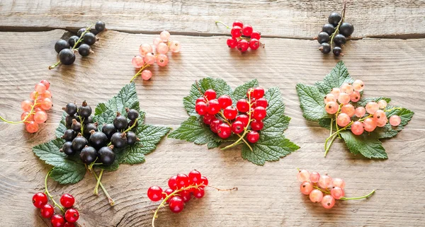 Fresh currant on leaves on the wooden board — Stock Photo, Image