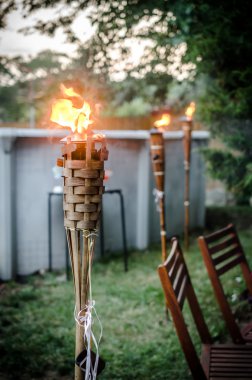 Burning tiki torch in the backyard clipart