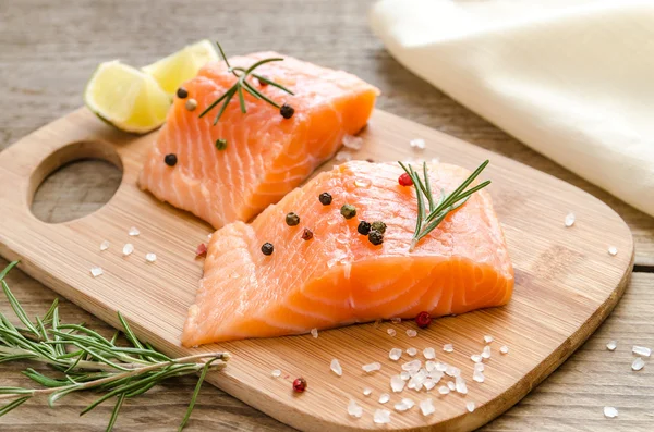 Raw salmon steaks on the wooden board — Stock Photo, Image