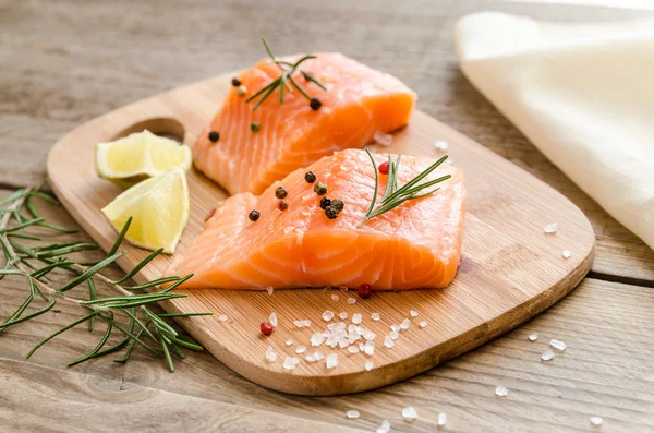 Filetes de salmón crudo en el tablero de madera — Foto de Stock