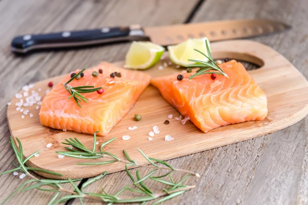 Filetes de salmón crudo en el tablero de madera — Foto de Stock