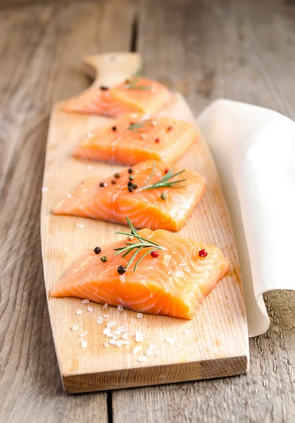 Filetes de salmón crudo en el tablero de madera — Foto de Stock