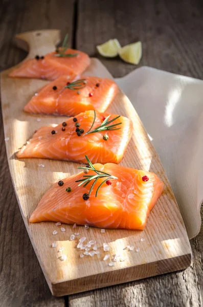 Filetes de salmón crudo en el tablero de madera —  Fotos de Stock