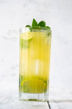 Beyaz arka planda bir bardak ananas mojito.