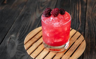 Böğürtlenlerle süslenmiş burbon yenileme kokteyli.