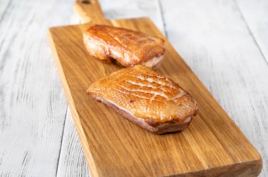 Kesme tahtasında kızarmış ördek göğsü.