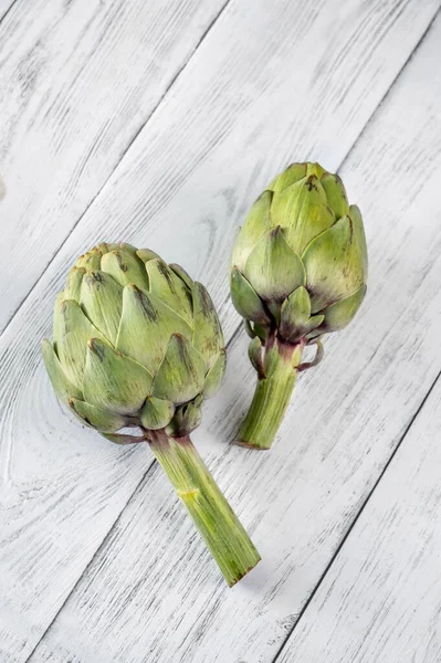 Two Uncooked Artichokes Wooden Table — Stock Photo, Image