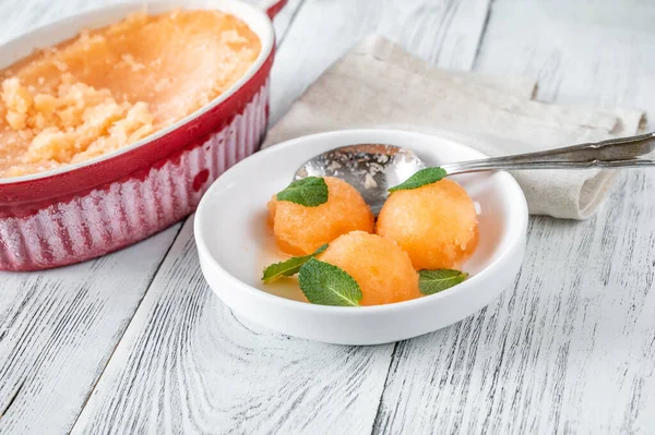 Cantaloupe-mint sorbet with fresh mint leaves in the white bowl