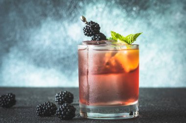 Blackberry Bourbon Smash cocktail garnished with lime and berries