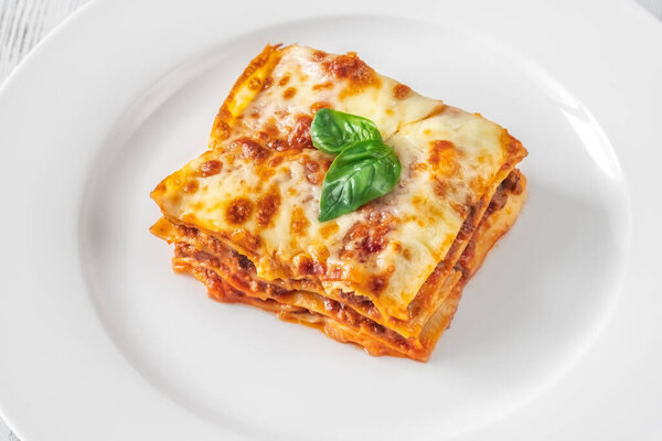 Portion of traditional italian lasagne on white plate