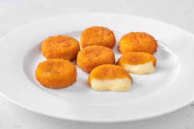Beyaz tabakta kızarmış camembert nugget.