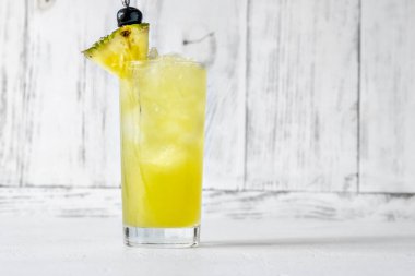 Bir bardak Chartreuse Swizzle kokteyli. Ananas dilimleriyle süslenmiş.