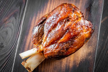 Ahşap kesme tahtasının üstünde pişmiş jambon.