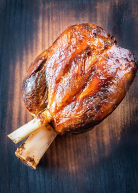 Ahşap kesme tahtasının üstünde pişmiş jambon.