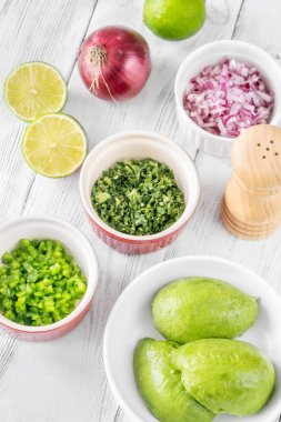 Guacamole için gereken malzemeler kaplarda.