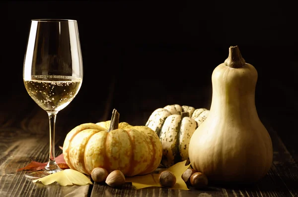 Kürbisse und Herbstblätter mit Weißwein Stockbild