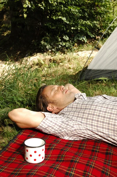 Человек, отдыхающий на одеяле - палаточный лагерь — стоковое фото